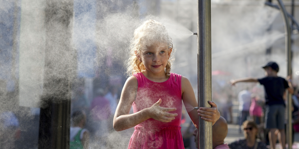 Una bambina si rinfresca a Parigi il 29 luglio 2024 (AP Photo/Vadim Ghirda)