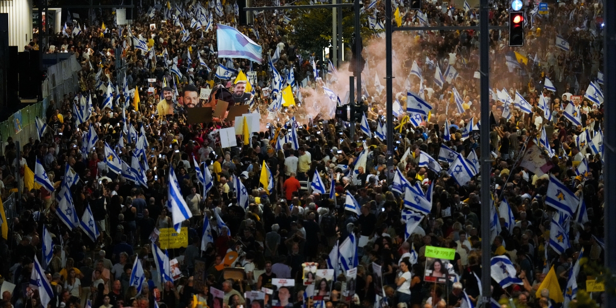 La manifestazione di sabato sera a Tel Aviv: si vedono molte bandiere bianche e azzurre, di Israele, e gialle, colore simbolo degli ostaggi (AP Photo/Ariel Schalit)