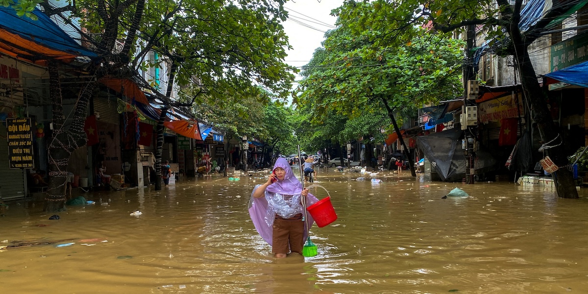 Una donna cammina in una strada allagata nella città di Thai Nguyen, mercoledì 11 settembre (REUTERS/ Thinh Nguyen)