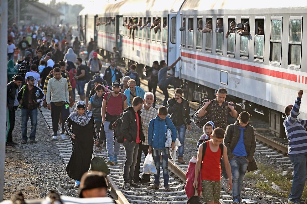 Una foto di un gruppo di migranti che attende la partenza di un treno dalla stazione croata di Tovarnik, 18 settembre 2015 