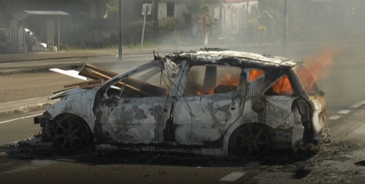 Un'auto incendiata a Fort-de-France, la capitale di Martinica (Fotogramma video via Le Figaro)