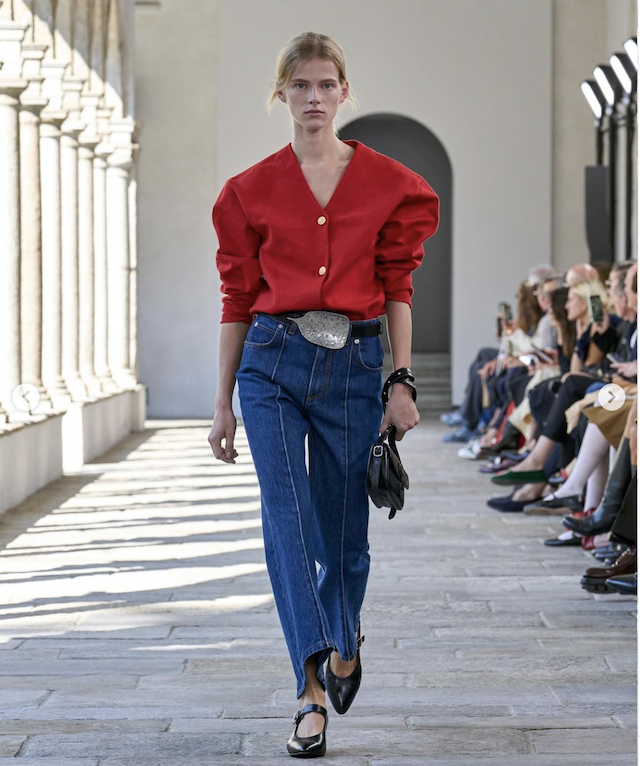 Un look di Bally com maglioncino rosso dalle spalle larghe e jeans