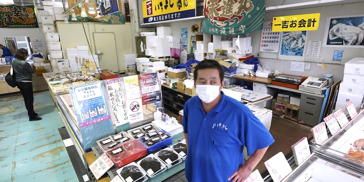 Una foto del proprietario di uno stand al mercato del pesce di Ichiyoshi, a Onahama, nella prefettura di Fukushima, 19 ottobre 2023 (AP/Eugene Hoshiko)