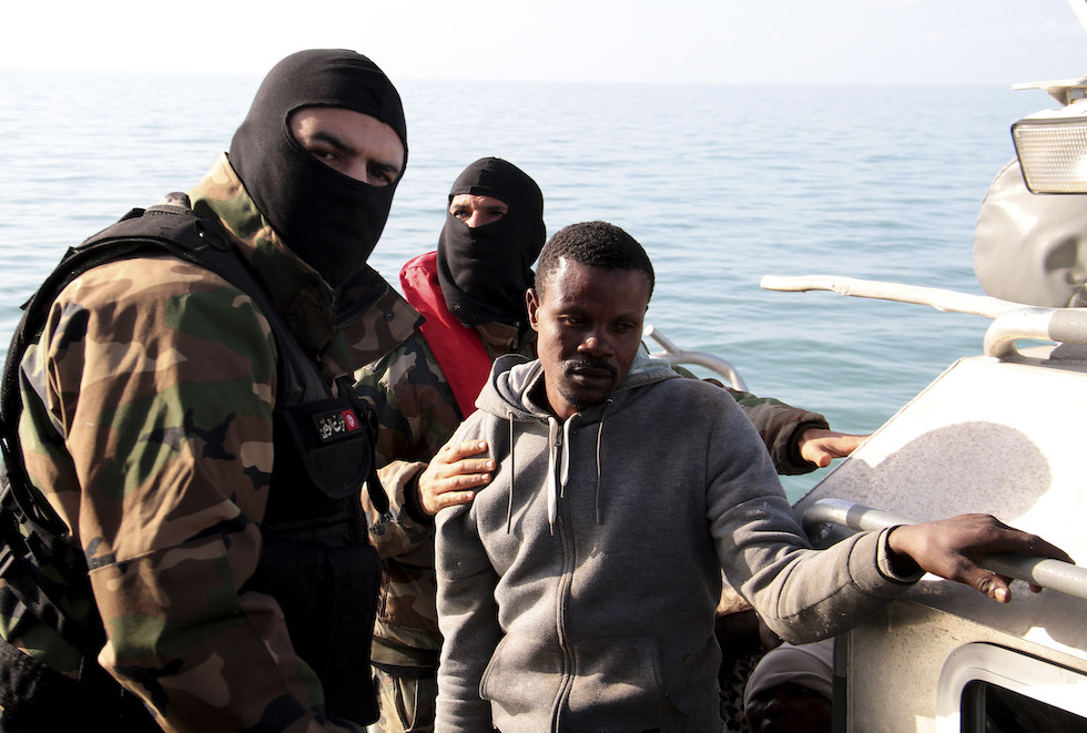 Una foto di un agente della Garde Nationale tunisina ferma un'imbarcazione di migranti subsahariani diretta in Italia, 18 aprile 2023