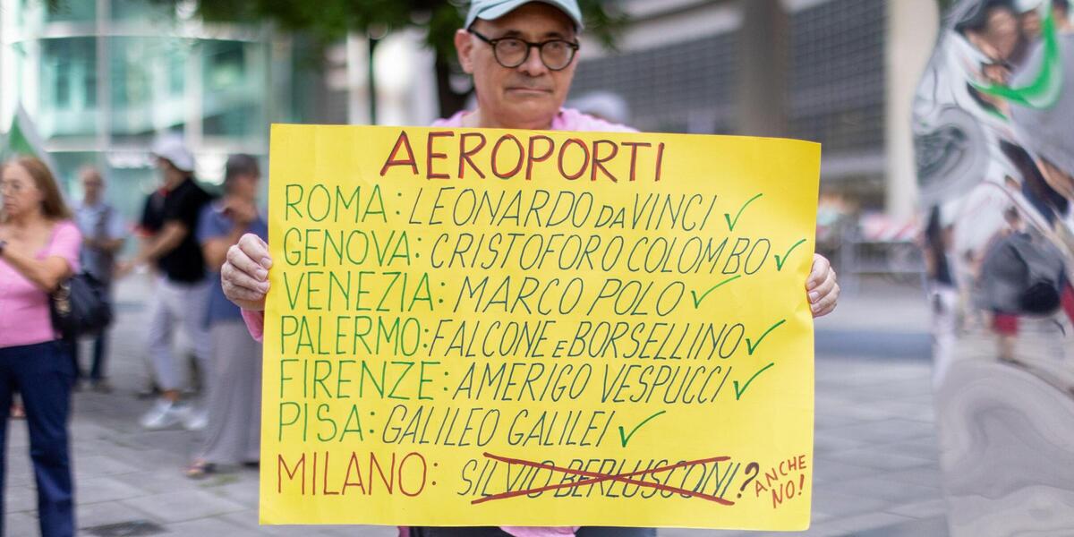 Un uomo manifesta contro l'intitolazione dell'aeroporto di Malpensa a Silvio Berlusconi (Stefano Porta / LaPresse)