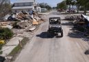 Un veicolo su una strada con macerie di case a Cedar Key, in Florida (AP Photo/Gerald Herbert)