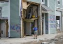 Una donna osserva una casa semi-distrutta dalla tempesta Helene a Cedar Key, in Florida (AP Photo/Gerald Herbert)