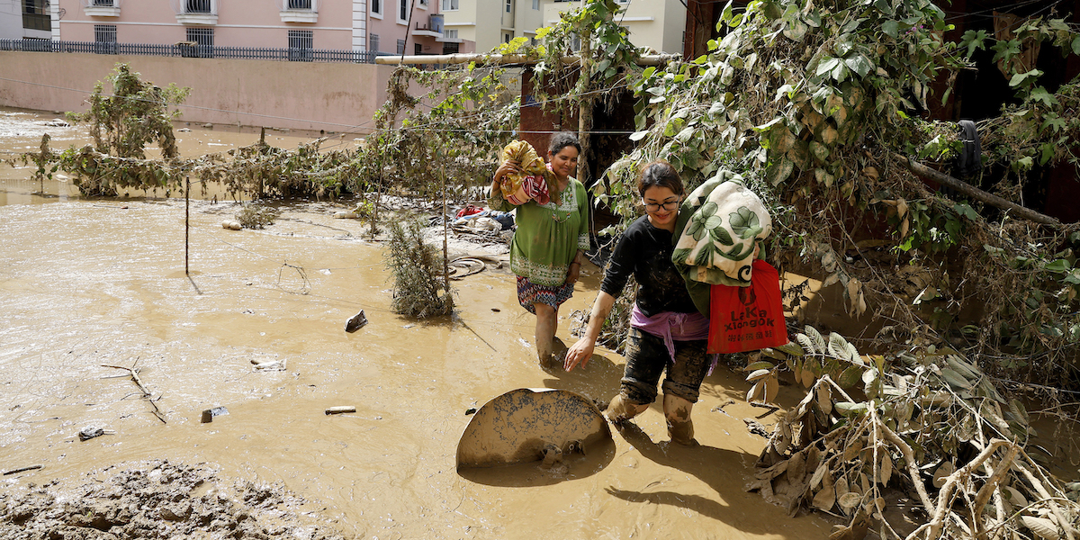 Due donne camminano nel fango a Katmandu, in Nepal, 30 settembre 2024 (AP Photo/Gopen Rai)