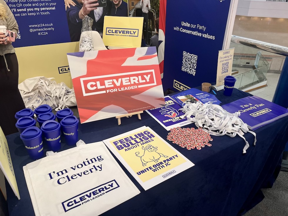 Lo stand di Cleverly: il merchandising è andato forte, soprattutto quello di Tugendhat, mentre lo staff di Jenrick ha stampato una specie di giornale (Il Post)