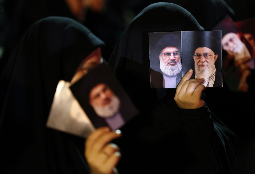 Donne a Beirut con in mano foto di Hassan Nasrallah e di Ali Khamenei