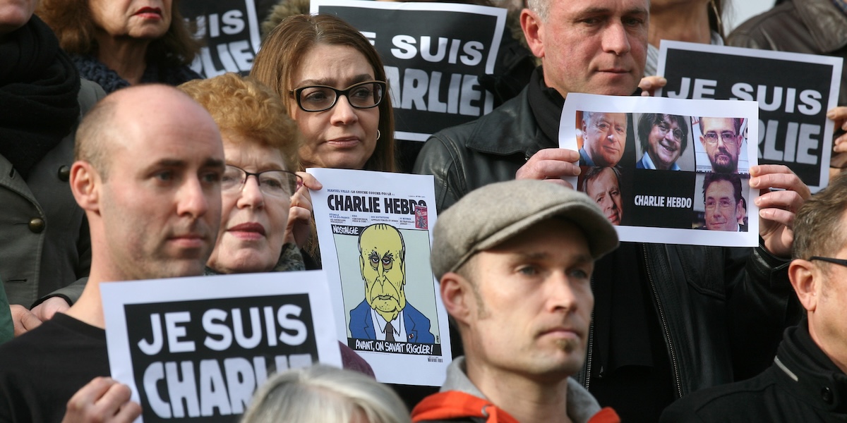 Persone mostrano cartelli con scritto “Io sono Charlie [Hebdo]” durante una manifestazione a Cannes, il 9 gennaio del 2015 (AP Photo/ Lionel Cironneau)