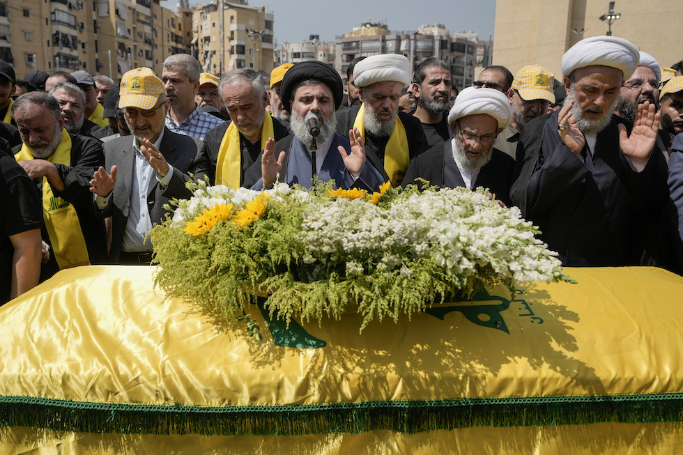 Hashem Safieddine, dietro al microfono, mentre parla al funerale di un comandante di Hezbollah ucciso