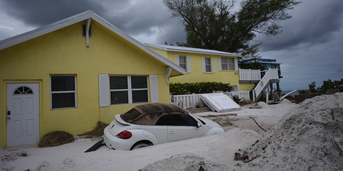 Un'auto sommersa dalla sabbia a Bradenton Beach, dopo il passaggio della tempesta Helene (AP Photo/Rebecca Blackwell)