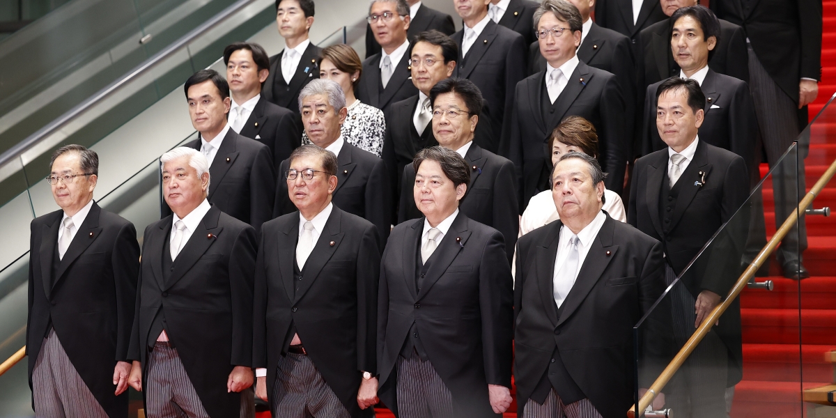 La foto originale: sotto alla giacca del primo ministro Shigeru Ishiba (al centro in prima fila) sbuca un poco elegante triangolo di camicia, che è stato rimosso in un'altra versione (Rodrigo Reyes Marin - Pool/Getty Images)