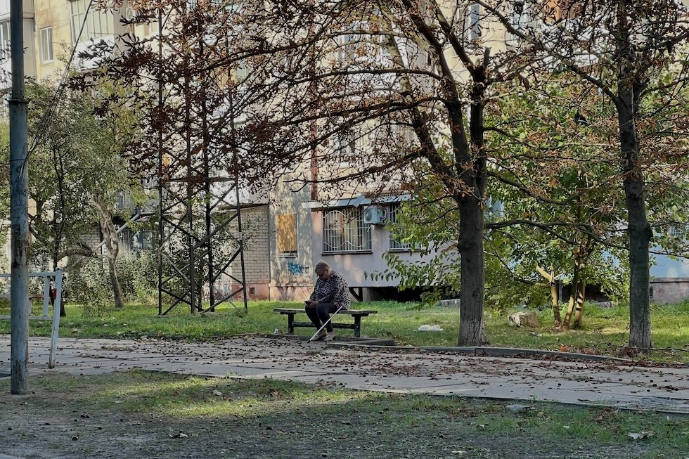 Foto di un'ucraina seduta sotto a un albero a Kherson 