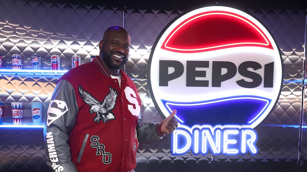 Shaquille O’Neal sorride davanti all'insegna del ristorante