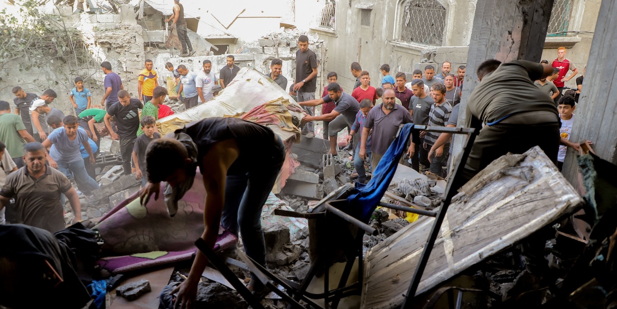 Alcuni cittadini tra le macerie di un edificio colpito da un altro bombardamento israeliano vicino al campo profughi di Jabalia, 5 ottobre 2024 (Abood Abusalama ABACAPRESS via ANSA)