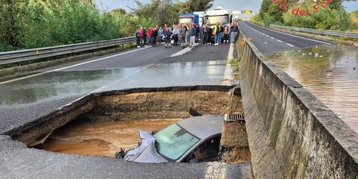 Un'auto è caduta in una voragine sulla strada statale 280 a Lamezia Terme, in Calabria, 21 ottobre 2024 (Vigili del Fuoco/Ansa)