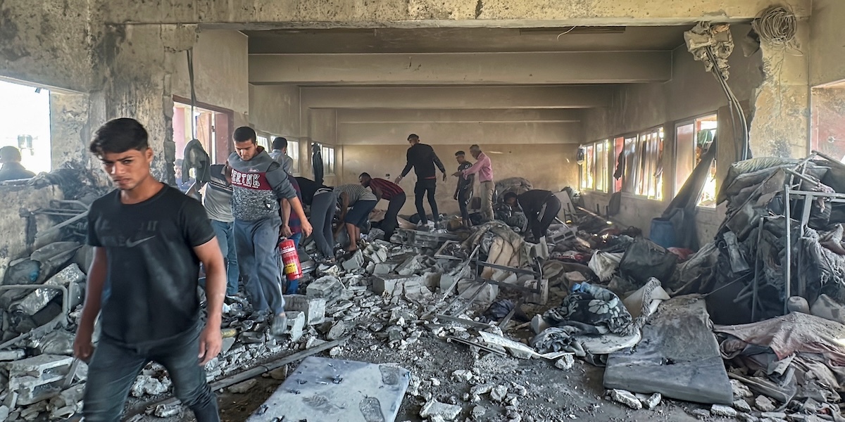 Un gruppo di uomini tra le macerie di un edificio bombardato