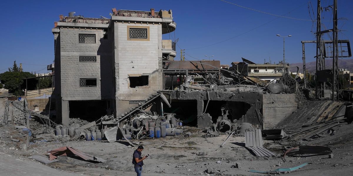 Un giornalista a Temnin, un paese della valle della Beqaa bombardato da Israele il 5 ottobre (AP Photo/Hassan Ammar)