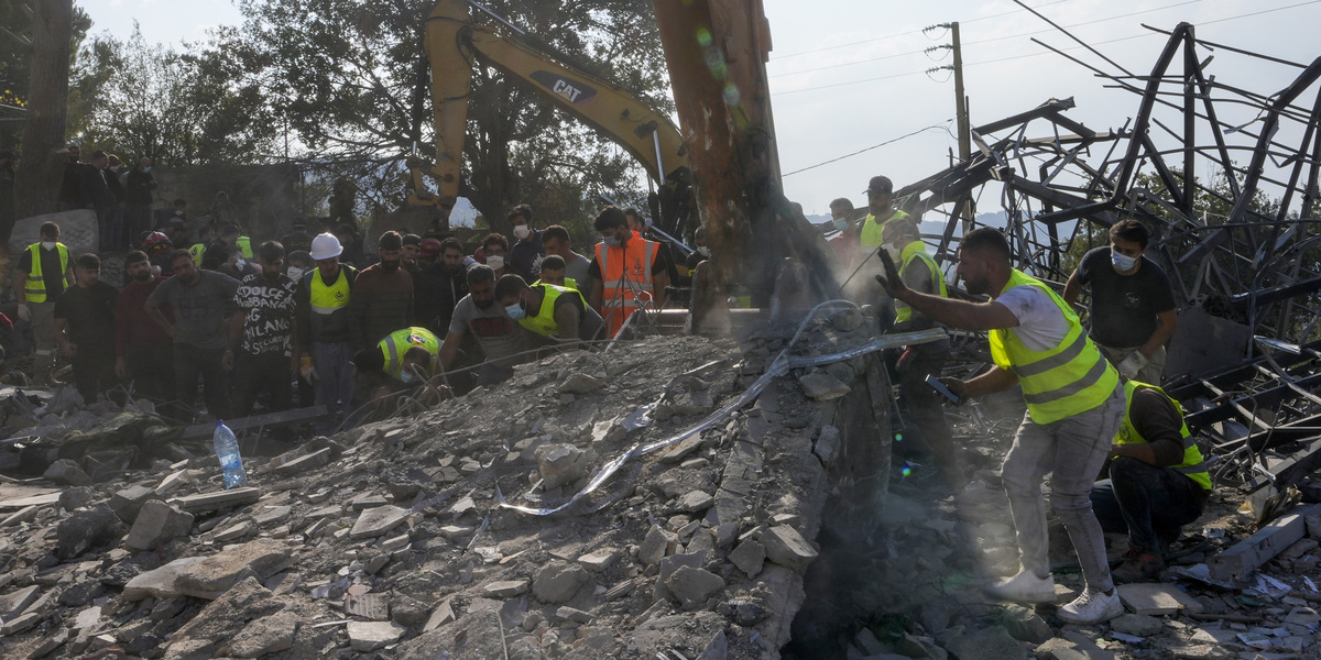 Un gruppo di soccorritori cerca eventuali morti e feriti tra le macerie dopo l'attacco ad Almat (AP Photo/Hassan Ammar)