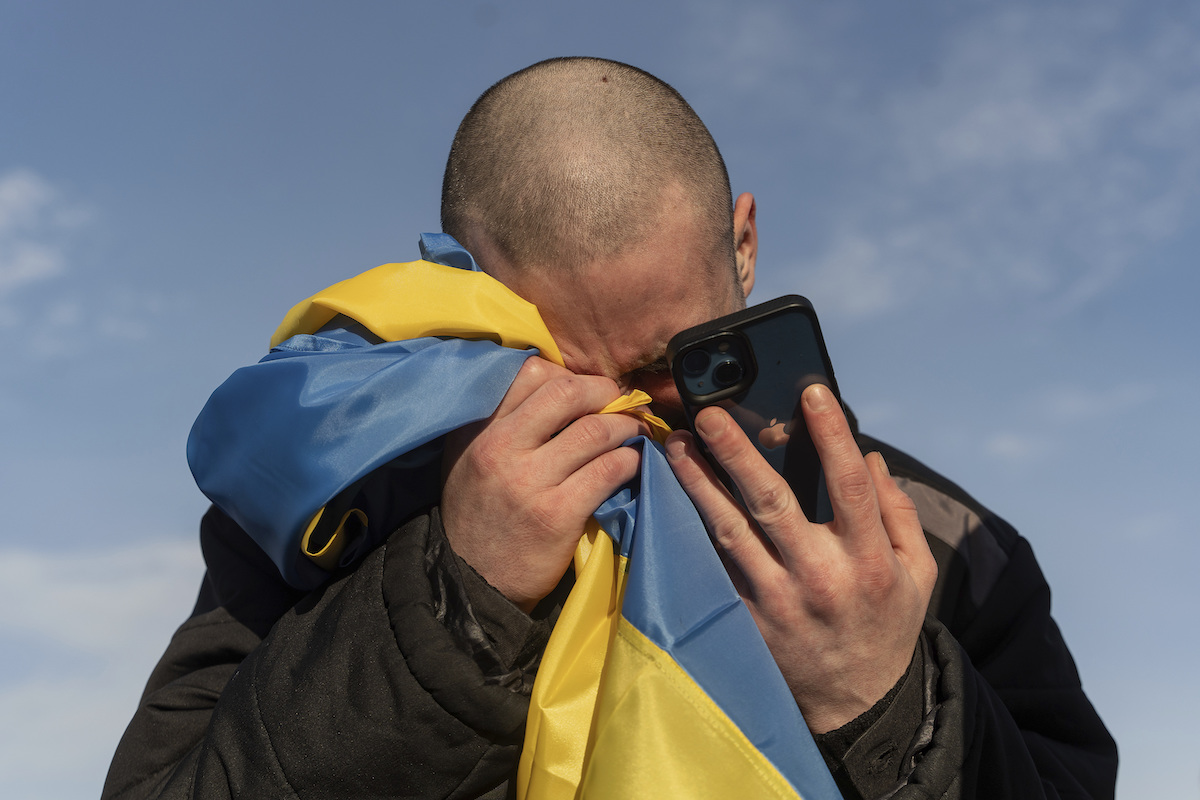 Foto di un prigioniero di guerra ucraino appena liberato dopo uno scambio di prigionieri piange mentre parla al telefono con la sua famiglia (AP Photo/Danylo Pavlov)