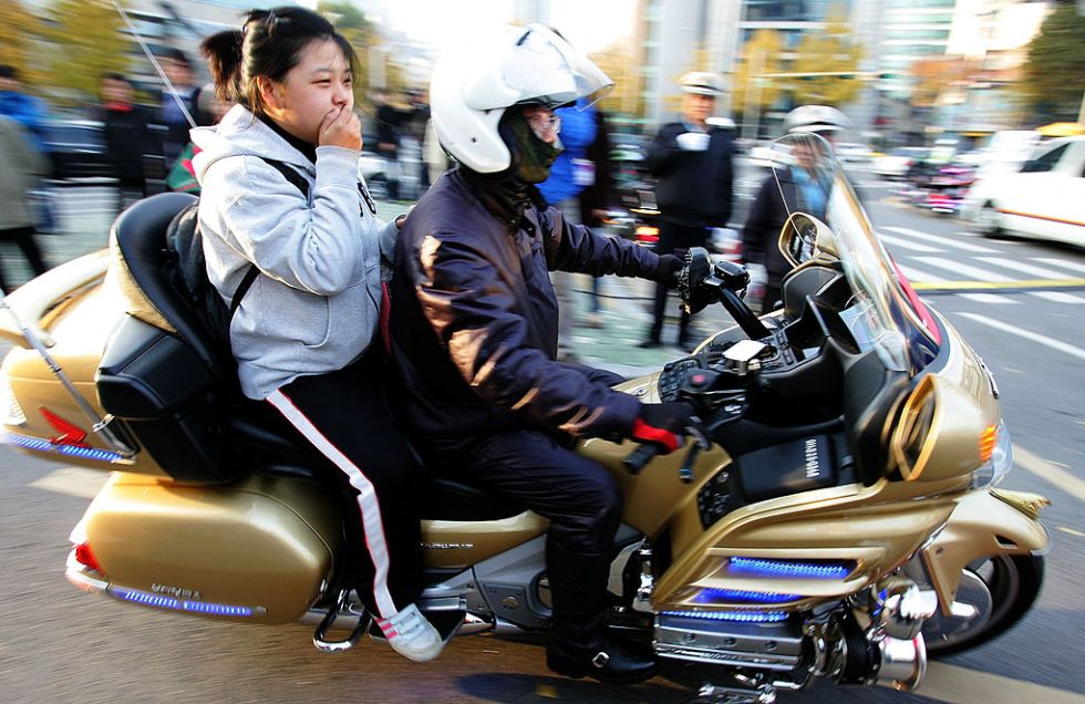 Una studente arriva alla propria sede del Senung a bordo di una moto della polizia, a Seoul nel 2008