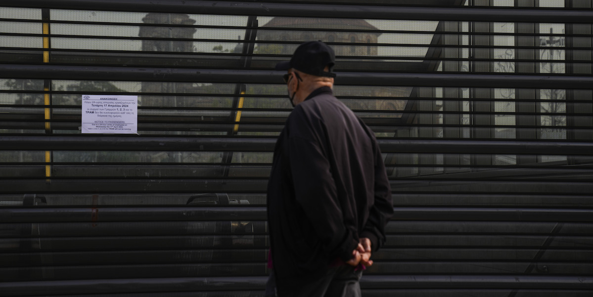 Un uomo davanti a una stazione della metropolitana chiusa per sciopero, Atene, 17 aprile 2024 (AP Photo/Petros Giannakouris)