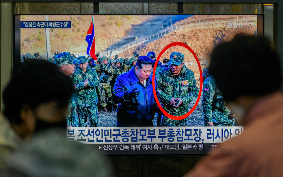 Kim Yong Bok, cerchiato e con un taccuino in mano, vicino a Kim Jong Un in un video trasmesso dalla televisione sudcoreana 