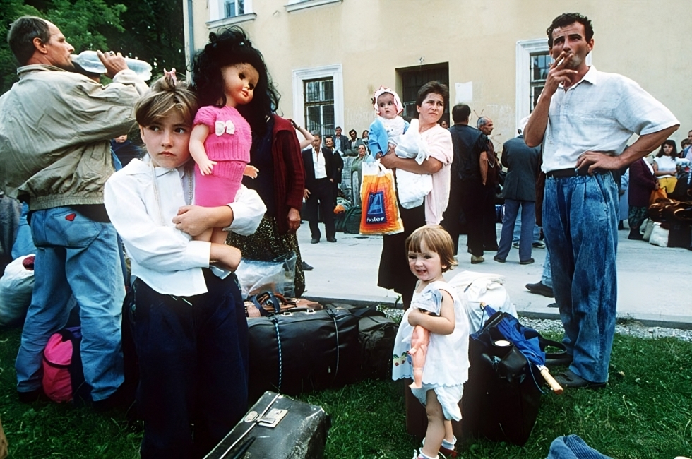 Una bambina rifugiata stringe una bambola dopo essere arrivata con la propria famiglia nella città bosniaca di Travnik, nel 1993