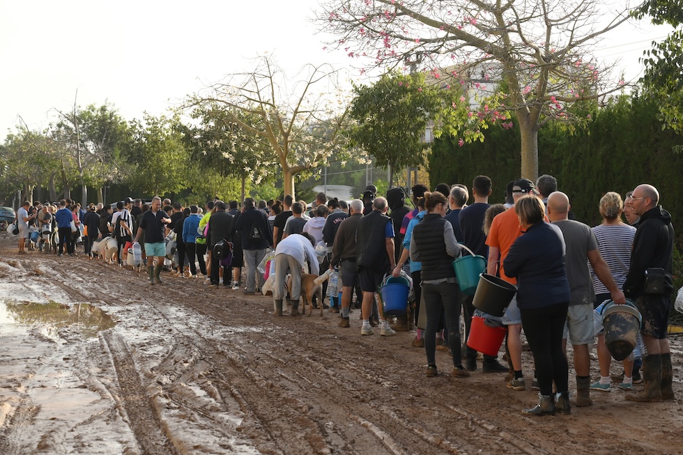 Persone in fila nel fango