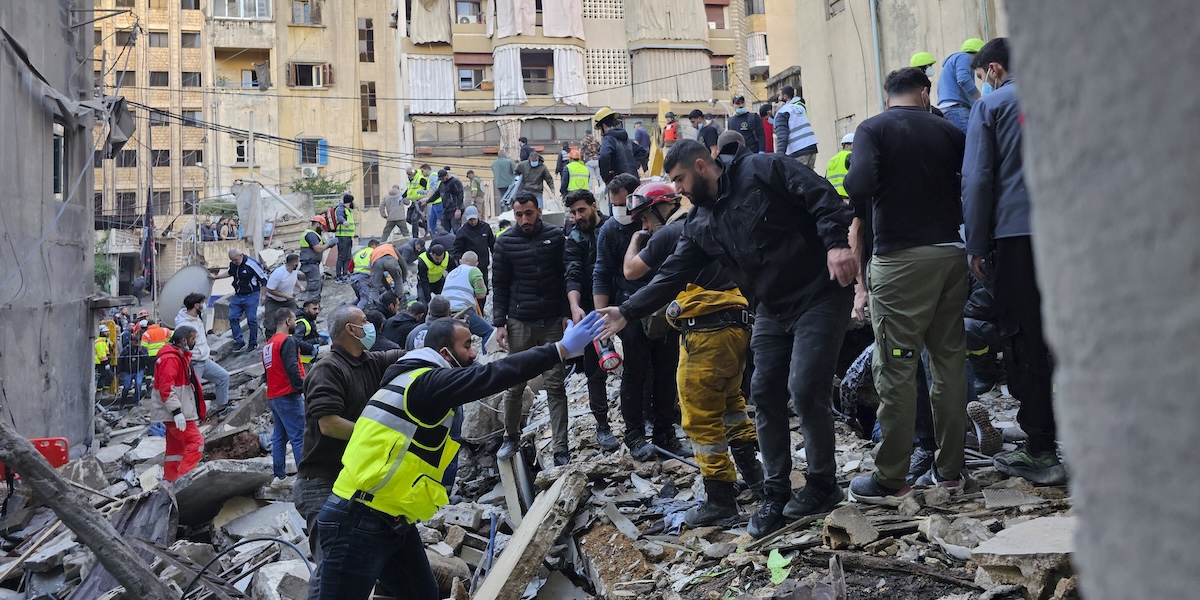 I soccorritori cercano le vittime sul luogo dell'attacco aereo israeliano a Beirut, Libano, 26 novembre 
(AP Photo/Hassan Ammar)