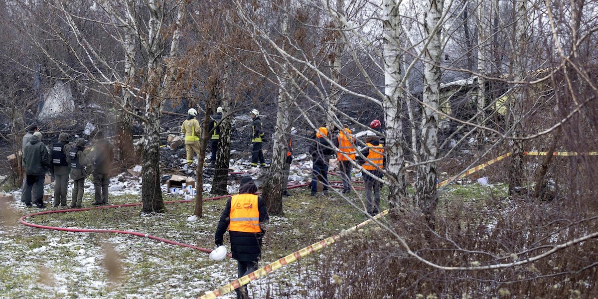 I soccorritori sul posto dove è caduto l'aereo cargo a Vilnius, in Lituania, 25 novembre 2024 (AP Photo/Mindaugas Kulbis)