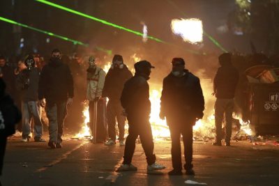 Un piccolo rogo dietro un gruppo di manifestanti