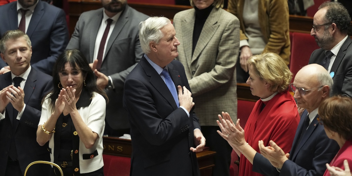 Il primo ministro francese Michel Barnier riceve applausi subito dopo il voto di sfiducia in parlamento, il 4 dicembre 2024 (AP Photo/Michel Euler)