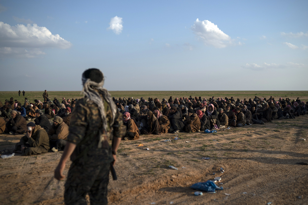 In questa foto del 2019, un combattente delle SDF sorveglia persone uscite da Baghouz, l'ultima città dell'ISIS caduta