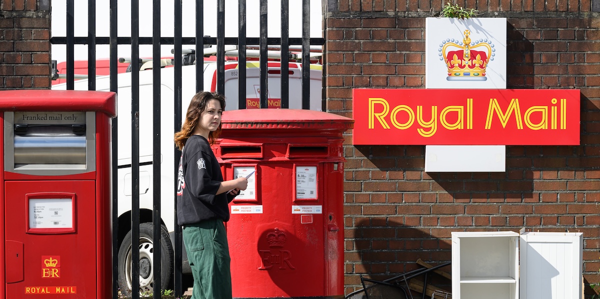 Una ragazza davanti a una cassetta della posta della Royal Mail a Uxbridge, 29 maggio 2024 (Leon Neal/ Getty Images)