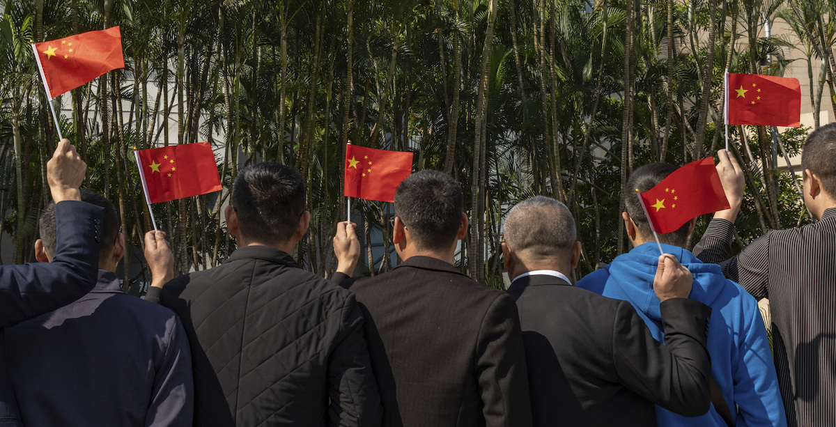 Persone a Macao sventolano bandierine cinesi