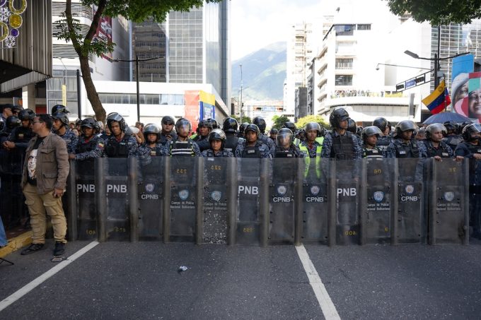 Poliziotti in assetto antisommossa alla protesta dell'opposizione a Caracas, il 9 gennaio 